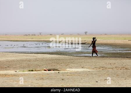 Dassanech-Frau, die am Ufer des Turkana-Sees, der Grenze Äthiopiens und Kenias, spazieren geht Stockfoto