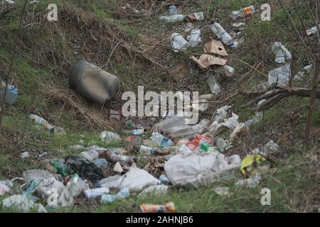 Elemental dump plastik Müll am Straßenrand in der Nähe am Rande des Waldes. Verschmutzung der Umwelt mit Kunststoff- und andere Abfälle. Stockfoto