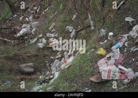 Elemental dump plastik Müll am Straßenrand in der Nähe am Rande des Waldes. Verschmutzung der Umwelt mit Kunststoff- und andere Abfälle. Stockfoto
