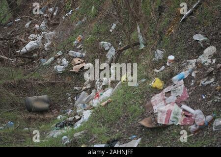 Elemental dump plastik Müll am Straßenrand in der Nähe am Rande des Waldes. Verschmutzung der Umwelt mit Kunststoff- und andere Abfälle. Stockfoto