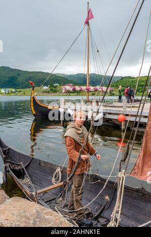 Lofotr, Norwegen - 2. August 2017 Mann Vorbereitung rekonstruierten Wikingerschiff liegt an der Grenze des Innerpollen salzigen See in Vestvagoy Insel der Lofoten Coban Stockfoto