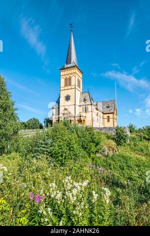 Blick auf Vagan Kirche, genannt Lofoten Kathedrale, von der Piste mit Grünpflanzen und Blumen bedeckt. Kabelvag Village in Insel Austvagoya, Nordland, Stockfoto