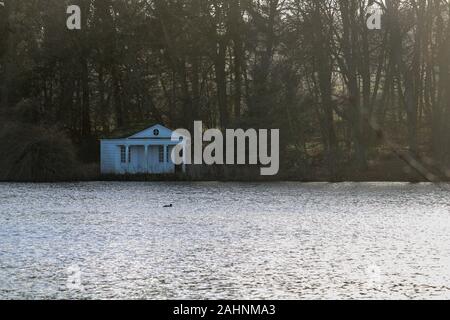 Die Sonne beleuchtet die Bäume und glänzt auf dem See auf Gut Panker in der Nähe von Kiel, Deutschland Stockfoto