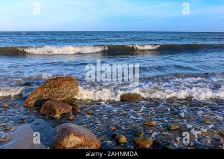 Wellen brechen auf die Steine an der Ostsee Strände in der Nähe von Hohwacht, Deutschland Stockfoto