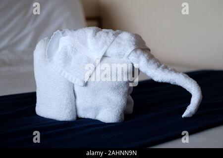 Ein Handtuch Origami-Tier, das aus Hoteltüchern in Form eines Elefanten besteht. Das Zimmer wurde vom Zimmerservice auf dem Bett der Gäste belassen Stockfoto