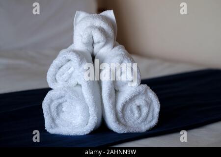 Ein Handtuch Origami-Tier, das aus Hoteltüchern in Form eines Bären besteht. Das Zimmer wurde vom Zimmerservice auf dem Bett der Gäste belassen Stockfoto