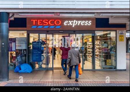 Menschen gehen in Tesco Express Stores in Coventry City Centre, West Midlands, UK. Stockfoto