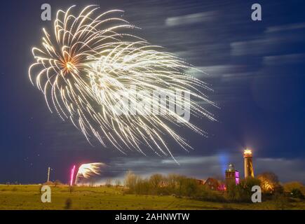 Putgarten, Deutschland. 31 Dez, 2019. Feuerwerk glühen in den Abendhimmel über dem Leuchtturm (r), das im Jahr 1901 erbaut wurde und das historische Schinkel Turm aus dem Jahre 1827 am Kap Arkona auf der Insel Rügen. Kap Arkona ist der nördlichste Punkt der Insel Rügen. Während die 35 Meter hohe Gebäude, das 1901 errichtet wurde, immer noch Licht sendet Signale über das Meer, die Schinkel Turm dient als Museum. Beide Gebäude können als Aussichtstürme geklettert werden. Foto: Patrick Pleul/dpa-Zentralbild/ZB/dpa/Alamy leben Nachrichten Stockfoto