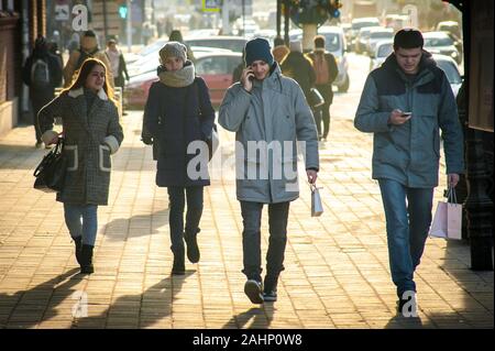 Tambow, Tambow, Russland. 31 Dez, 2019. Junge Menschen mit Smartphones und zwei Mädchen zu Fuß die Straße runter. Das Bild wurde am Sovetskaya Street in Tambow Kredit genommen: Demian Stringer/ZUMA Draht/Alamy leben Nachrichten Stockfoto