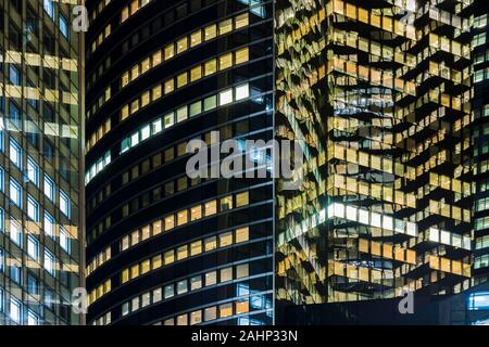 Licht und Reflexionen von Windows einige moderne Geschäftshäuser in der Nacht. Wahre Zustand des Geschäfts Stockfoto