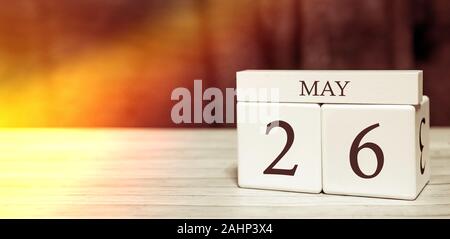 Kalender Reminder Veranstaltung Konzept. Holzwürfel mit Nummern und Monat am 26. Mai mit Sonnenlicht. Stockfoto