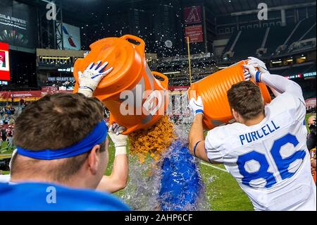 Die US Air Force Academy Football spieler Jared Bair und Michael Purcell armen Cheez-Its und Gatorade über Head Coach Troy Calhoun während der Feiern nach Sieg über Washington State University in der Cheez-It Schüssel Meisterschaftspiel bei Chase Field Dezember 27, 2019 in Phoenix, Arizona. Air Force besiegt Staat Washington 31-21 ihre Saison mit einem 11-2 Rekord und acht Spiel zu beenden Gewinnstreifen ist damit die dritte beste Jahreszeit in der Programmgeschichte. Stockfoto