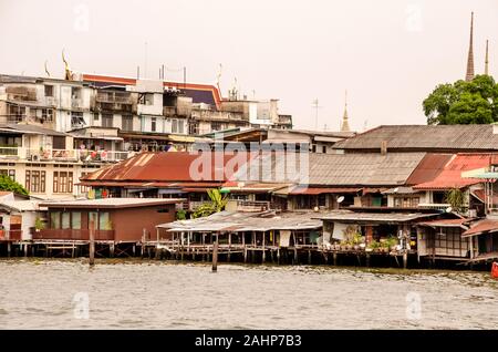 BANGKOK, THAILAND - 23. Dezember 2018: die alten hölzernen Slums für die benachteiligten armen auf Pfählen am Ufer des Chao Praya Fluss in Bangkok, Thailand Stockfoto