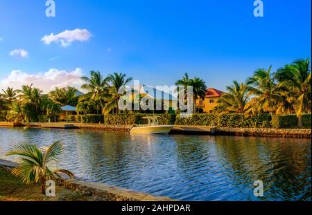 Grand Cayman, Cayman Island, Jan2019, Boot in einem Wohngebiet bei Sonnenuntergang auf einem Kanal führenden zum Karibischen Meer in West Bay günstig Stockfoto