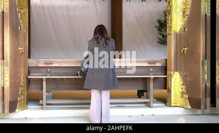 Tokio, Japan - April, 10, 2018: Eine japanische Anbeterin betet am Meiji Schrein in Tokio Stockfoto