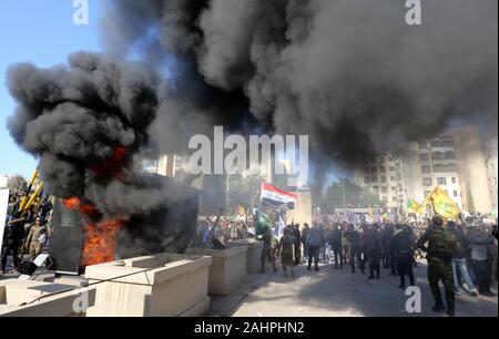 Bagdad, Irak. 31 Dez, 2019. Die Demonstranten brennen Eigentum vor der US-Botschaft in Bagdad, Irak, Dienstag, Dezember. 31., 2019. Dutzende von Angry irakischen schiitischen Miliz Unterstützer brach in die US-Botschaft in Bagdad am Dienstag nach Zertrümmern einer Eingangstür und Brand zu einer Rezeption, woraufhin Gas- und Klänge der Schüsse zerreißen. Zeugen sagten. Foto von humam Mohamed/UPI Quelle: UPI/Alamy leben Nachrichten Stockfoto