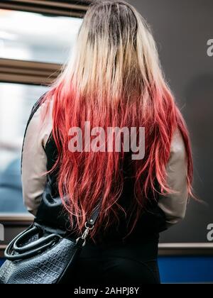 Nicht erkennbare junge Mädchen mit langen gefärbten Haaren steht in der Nähe der U-Bahn. Mode bei den Jugendlichen Haarfarbe hell Himbeere mit einem Trans Stockfoto