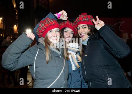 Nachtschwärmer aus Italien genießen Sie das straßenfest an der Princes Street während des Hogmanay Neujahrsfeiern in Edinburgh. Stockfoto