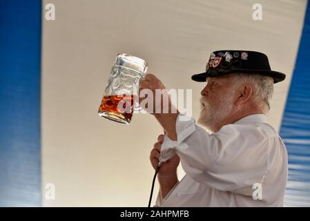 Polka Bandleader und Sänger, mit Alpen-Hut, führender Trink-Toast auf dem Oktoberfest in der schweizerisch-amerikanischen Gemeinde New Glarus, Wisconsin, USA. Stockfoto