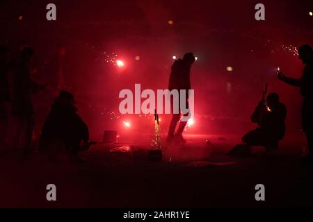 Koblenz, Deutschland. 01 Jan, 2020. Junge Männer licht Feuerwerk Raketen auf das Deutsche Eck vor dem Reiterstandbild von Kaiser Wilhelm am Zusammenfluss von Rhein und Mosel. Quelle: Thomas Frey/dpa/Alamy leben Nachrichten Stockfoto