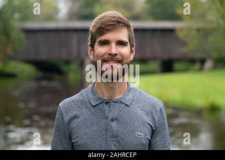 Self Portrait des Fotografen für Stock Fotografie Modellierung zur Verfügung. Covered Bridge und Landschaft im Hintergrund. Stockfoto