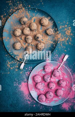 Hausgemachte vegan cacao Datum Cranberry und Mutter Energie Kugeln in der Moosbeere und Kakao Pulver abgedeckt Stockfoto