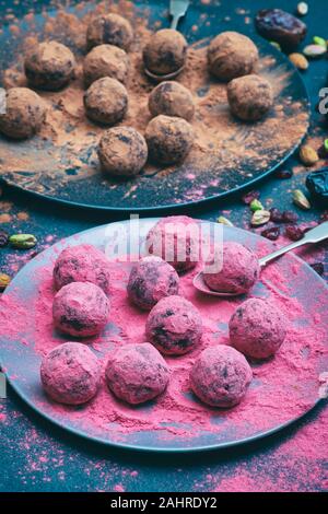 Hausgemachte vegan cacao Datum Cranberry und Mutter Energie Kugeln in der Moosbeere und Kakao Pulver abgedeckt Stockfoto