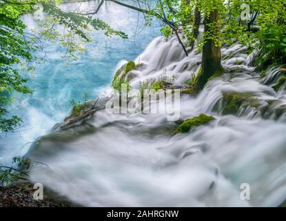 Lange Belichtung von oben auf einen Wasserfall, mit Wasser hetzen, vorbei an Bäumen und Pflanzen an den Rand der Wasserfälle. Nationalpark Plitvicer Seen, Kroatien. Stockfoto