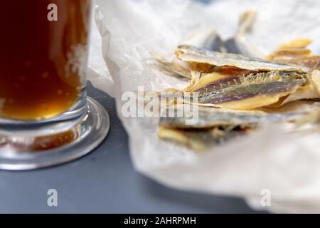 Gesalzener Fisch liegt in abgewickelten Papier. Stockfoto