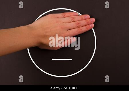 Hand geschlossen Augen von unglücklichen Smiley Stockfoto