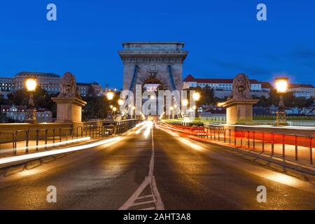 Dämmerung an der Kettenbrücke in Budapest, mit Schloss im Hintergrund. Stockfoto