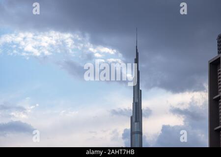 Burj Khalifa schließen oben mit bewölktem Himmel im Hintergrund. Seltene Wolkenbildung über UAE sky Stockfoto