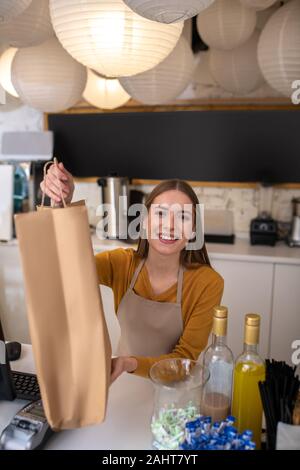 Lächelnd cafe Mitarbeiter geben einen um Ihr Client Stockfoto