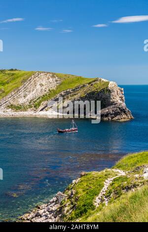 Ein Motorboot voller Urlauber Blätter Lulworth Cove für eine Tour entlang der Jurassic Heritage Coast Dorset, England, Großbritannien Stockfoto