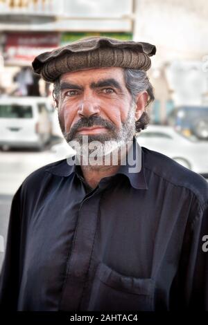 Mann mit einem traditionellen pakol Hut oder Chitral Kappe und einem weißen Bart in der Stadt von Khasab, Oman Stockfoto