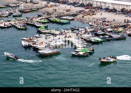 Iranische Schmuggler transportieren illigal landwirtschaftliche Erzeugnisse und Luxusgüter aus Oman in den Iran mit kleinen Booten vom Hafen von Khasab, Oman Stockfoto