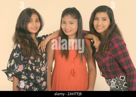 Studio shot von drei jungen schönen persischen Frauen als Freunde zusammen vor weißem Hintergrund Stockfoto