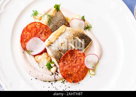 Zander Filet mit Chorizo, Blumenkohl und Radieschen in einem Restaurant. Close Up. Keto, Paleo, fodmap Diät essen. Stockfoto