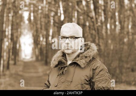 Closeup Portrait eines intelligenten Mann mit grauem Haar und Brille, Bart in eine Winterjacke. Toning, Sepia. Stockfoto