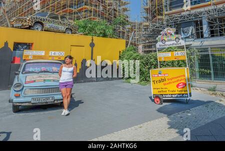 Junge Frau vor Trabi Welt Posing, Stadtrundfahrten und Autovermietung Stockfoto