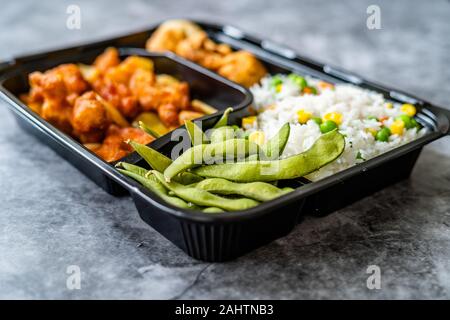 Entfernt die japanische Küche Bento Box Menü mit Huhn, gebratene Knödel, Edamame und Reis mit Gemüse in Kunststoffbox Paket/Container. Tradit Stockfoto