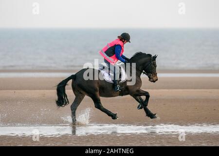 Southport, Merseyside, 1. Januar 2020. Reiter ihre Pferde für einen neuen Jahren Tag Galopp entlang der Ufer von Southport Strand in Merseyside. Credit: cernan Elias/Alamy leben Nachrichten Stockfoto