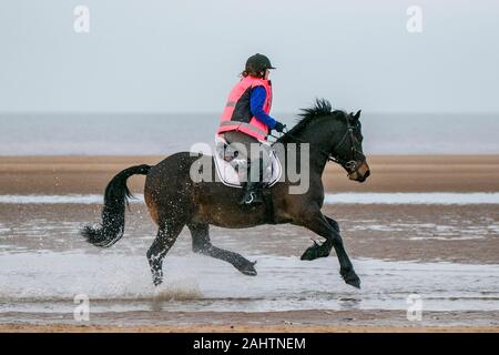 Southport, Merseyside, 1. Januar 2020. Reiter ihre Pferde für einen neuen Jahren Tag Galopp entlang der Ufer von Southport Strand in Merseyside. Credit: cernan Elias/Alamy leben Nachrichten Stockfoto