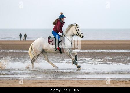 Southport, Merseyside, 1. Januar 2020. Reiter ihre Pferde für einen neuen Jahren Tag Galopp entlang der Ufer von Southport Strand in Merseyside. Credit: cernan Elias/Alamy leben Nachrichten Stockfoto