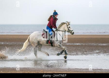 Southport, Merseyside, 1. Januar 2020. Reiter ihre Pferde für einen neuen Jahren Tag Galopp entlang der Ufer von Southport Strand in Merseyside. Credit: cernan Elias/Alamy leben Nachrichten Stockfoto