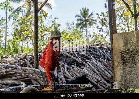 Die Crew captain bereitet die Brände unter den Schwefel Öfen in einer Verarbeitung Fabrik tief im Dschungel in der Nähe von Banyuwangi zu schüren, Ost Java, Indonesien. 10/12/19. Stockfoto