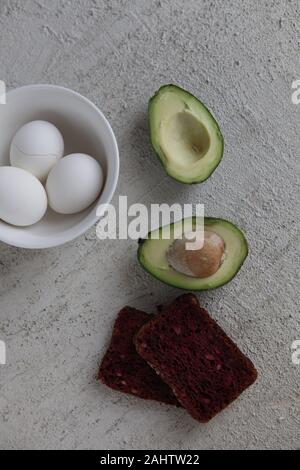 Leckeres Sandwich mit Avocado, Tomaten und pochierte Eier. Gesundes Frühstück oder Mittagessen Stockfoto