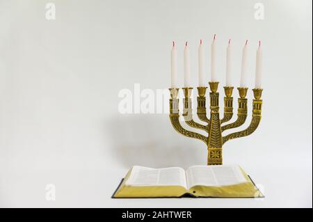 Menorah und offene Bibel mit 7 nicht leuchtende Kerzen auf weißem Hintergrund. Kopieren Sie Platz. Horizontale erschossen. Stockfoto