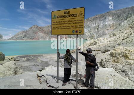 Indonesische Bergleute ein Zeichen Erwärmung Touristen weg von der See im Ijen Vulkan zu bleiben, Ost Java, Indonesien. 11/12/19. Stockfoto