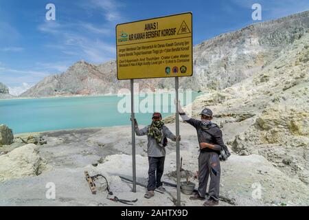 Indonesische Bergleute ein Zeichen Erwärmung Touristen weg von der See im Ijen Vulkan zu bleiben, Ost Java, Indonesien. 11/12/19. Stockfoto